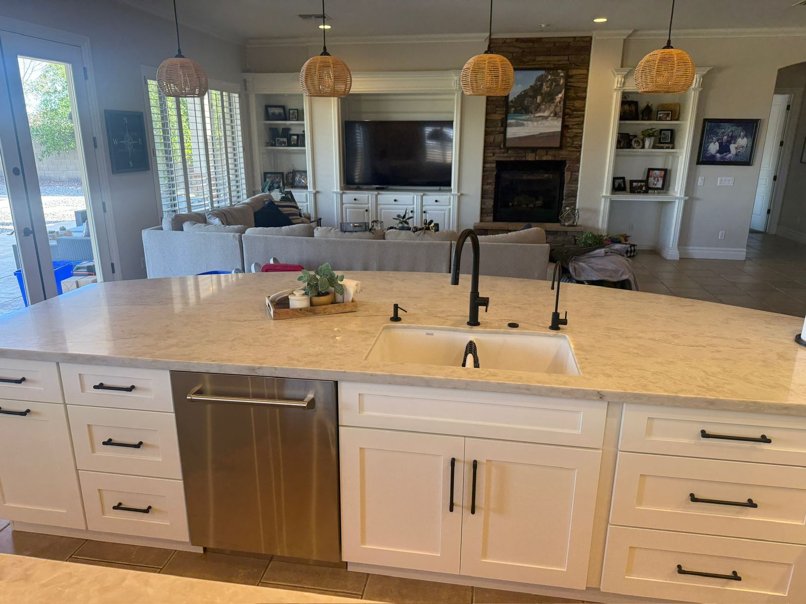 Stanley Brothers project: a kitchen island with an undermount sink looking through to a great room and fireplace
