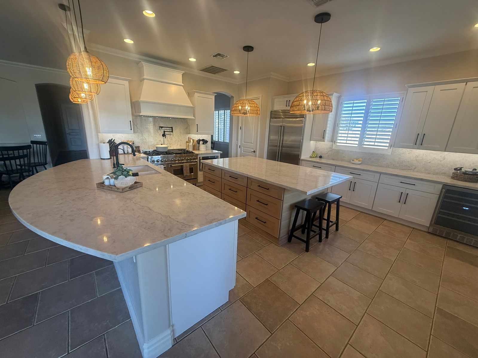 Stanley Brothers project: a kitchen seen from the dining side, two islands and a range wall under pendant lighting